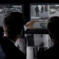 Private agents monitoring CCTV footage, searching for criminal, discussion